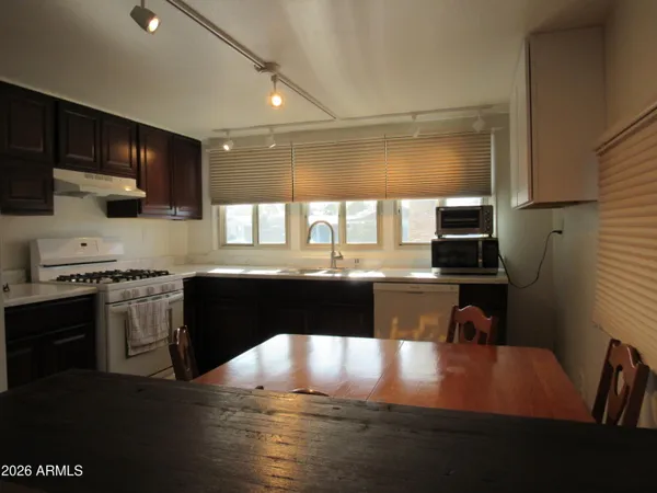 a kitchen with a table chairs sink and cabinets