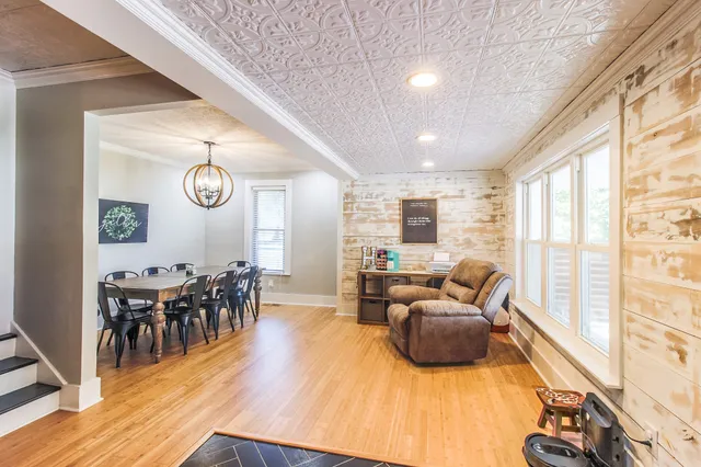 a living room with furniture wooden floor and a large window