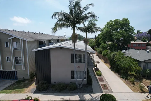 a white house with a large window and palm trees