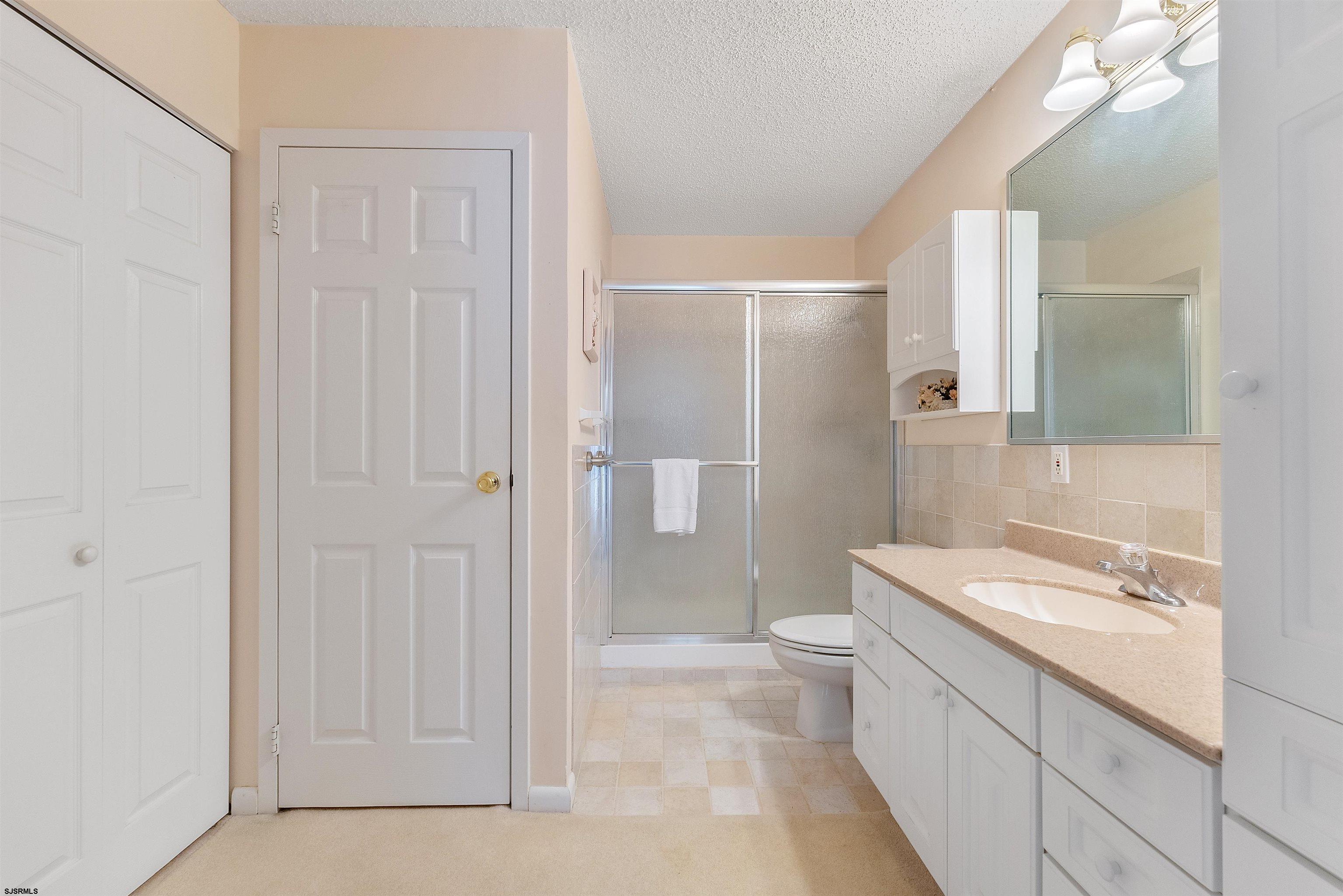 935 Ocean Avenue, Unit 319 Ocean City, NJ 08226 - Photo 11 of 24 a bathroom with a sink a toilet and shower