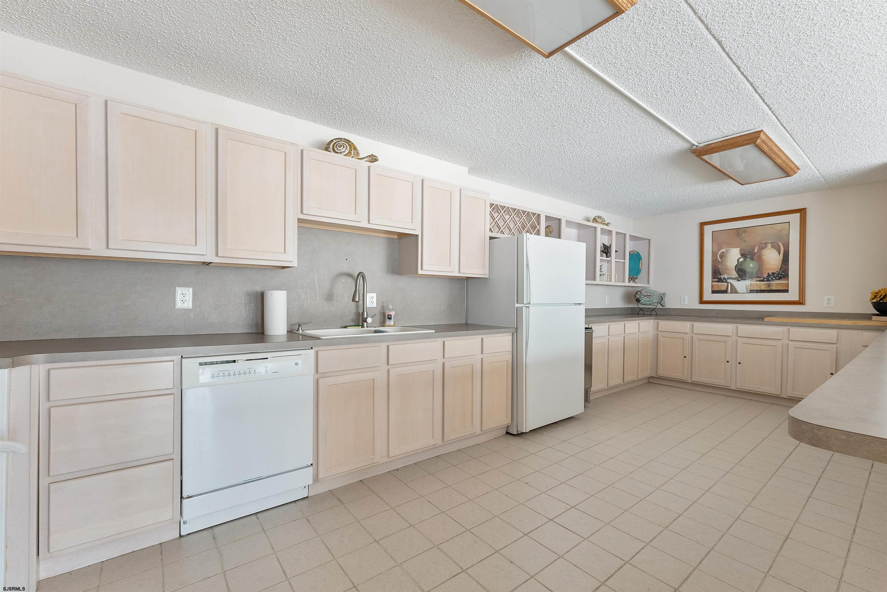 935 Ocean Avenue, Unit 319 Ocean City, NJ 08226 - Photo 19 of 24 a kitchen with white cabinets and white appliances