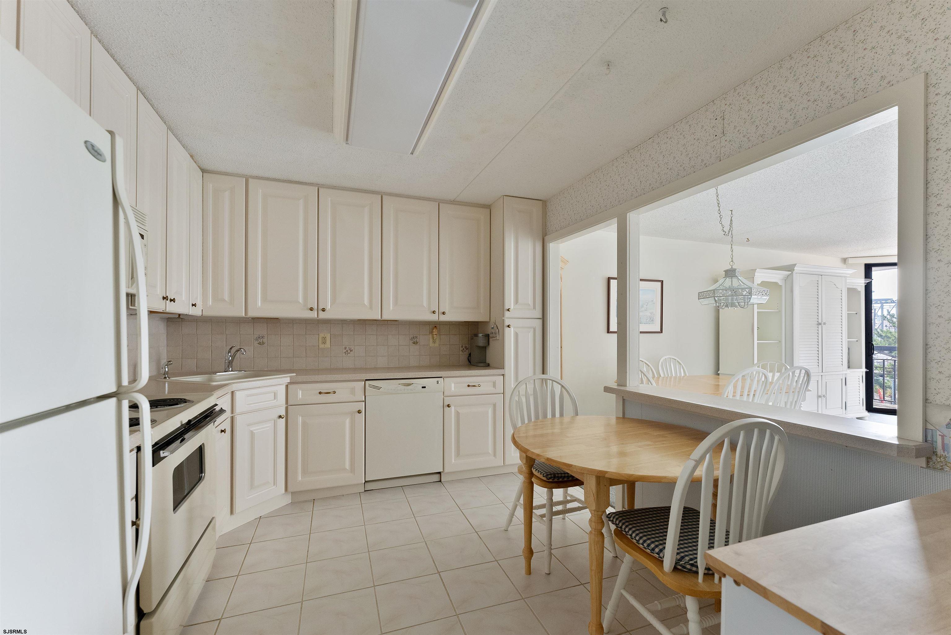 935 Ocean Avenue, Unit 319 Ocean City, NJ 08226 - Photo 3 of 24 a kitchen with cabinets and chairs