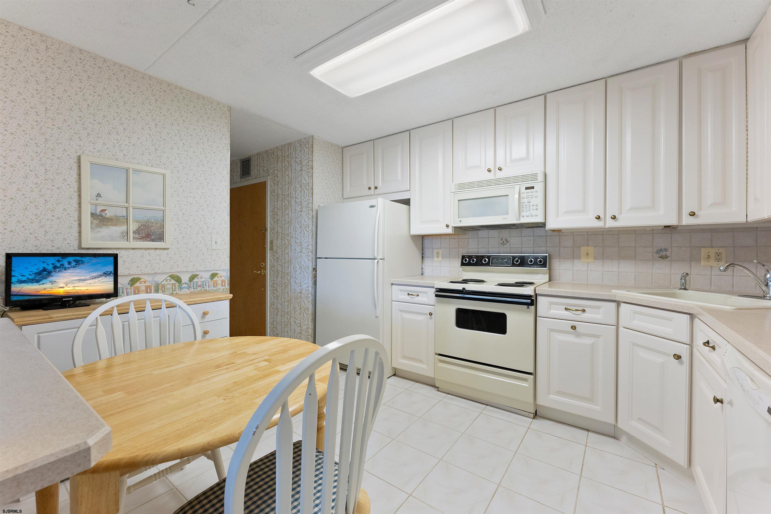 935 Ocean Avenue, Unit 319 Ocean City, NJ 08226 - Photo 4 of 24 a kitchen with cabinets appliances and a counter space