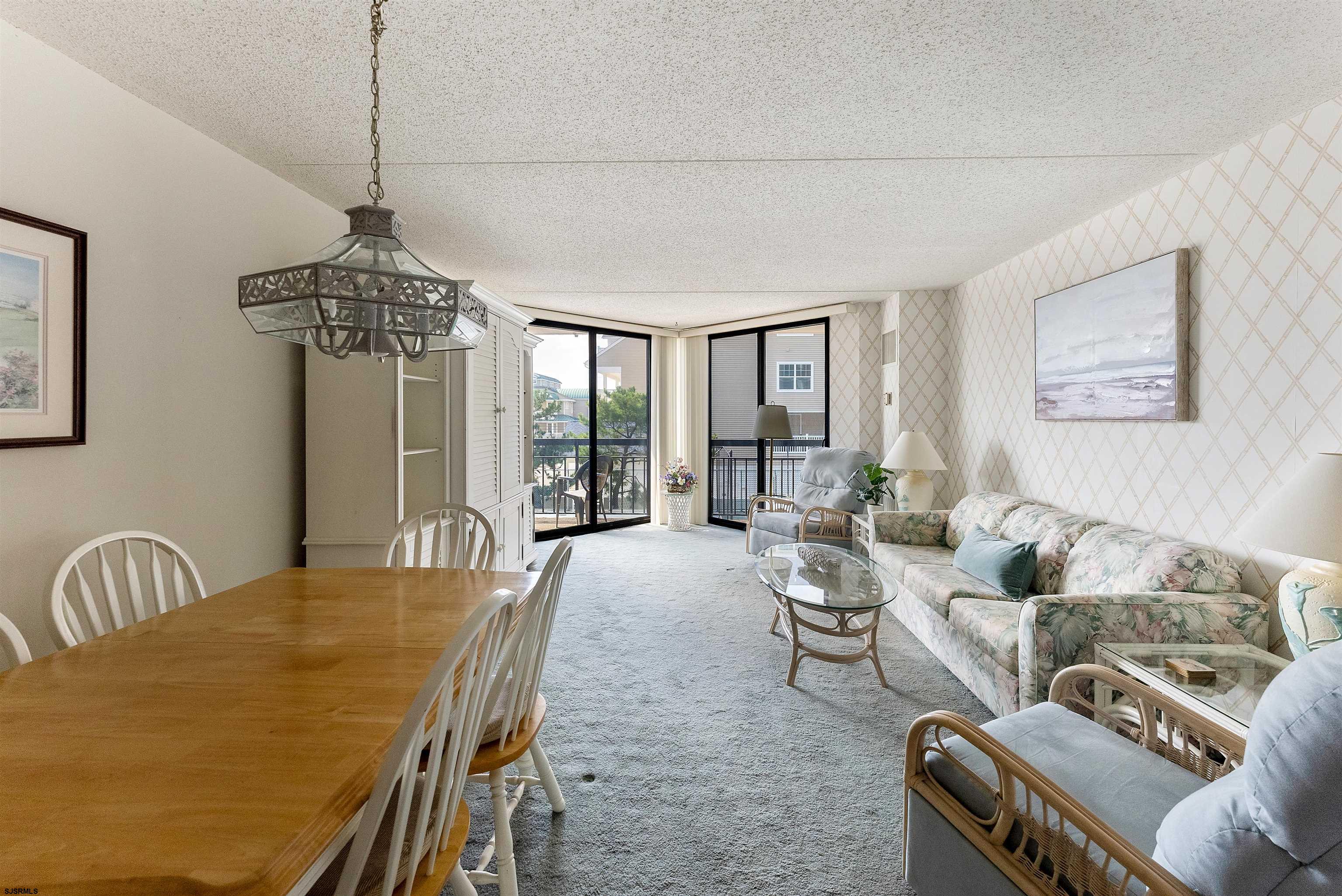 935 Ocean Avenue, Unit 319 Ocean City, NJ 08226 - Photo 5 of 24 a living room with furniture a chandelier and a dining table