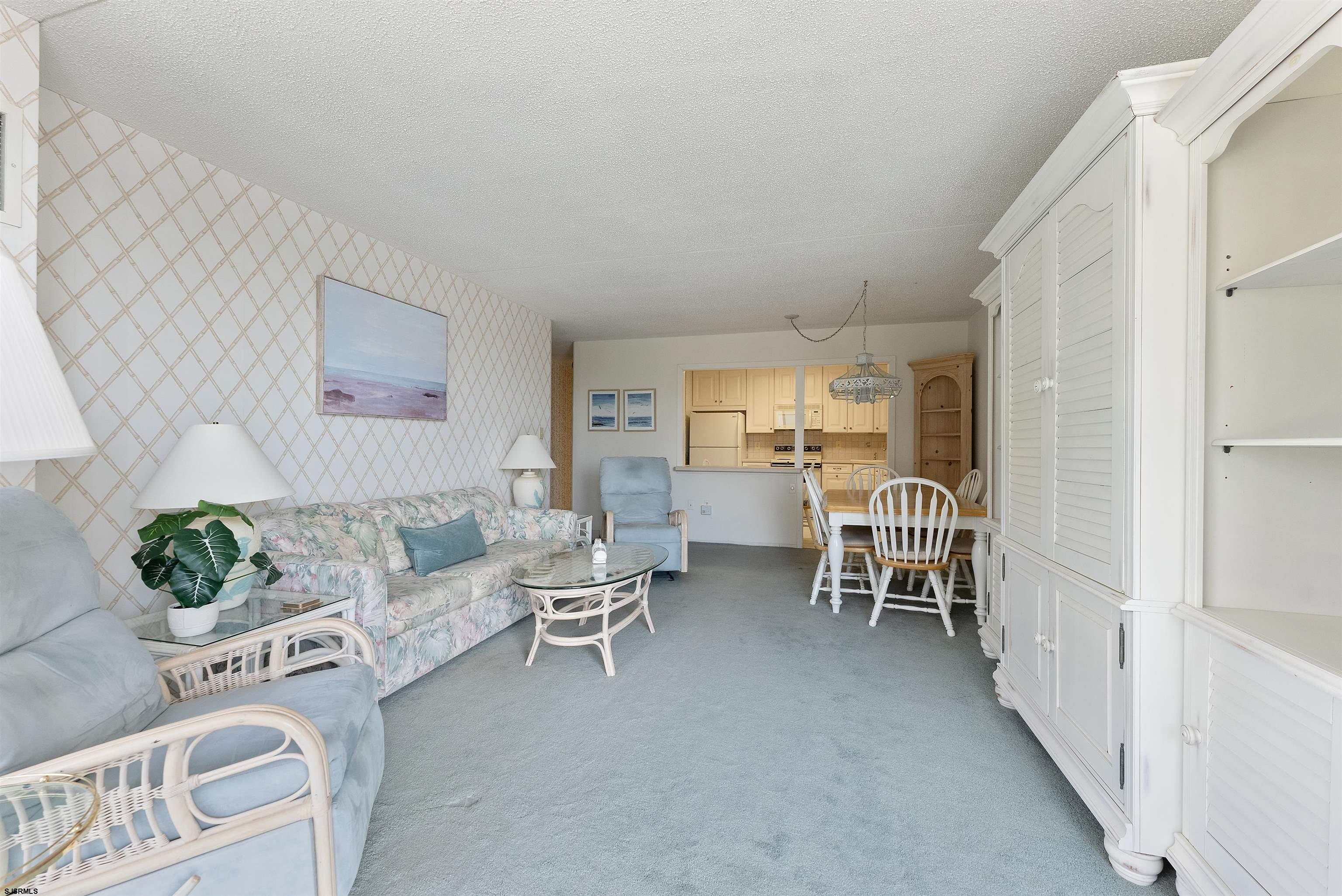 935 Ocean Avenue, Unit 319 Ocean City, NJ 08226 - Photo 6 of 24 a living room with furniture and a dining table with kitchen view