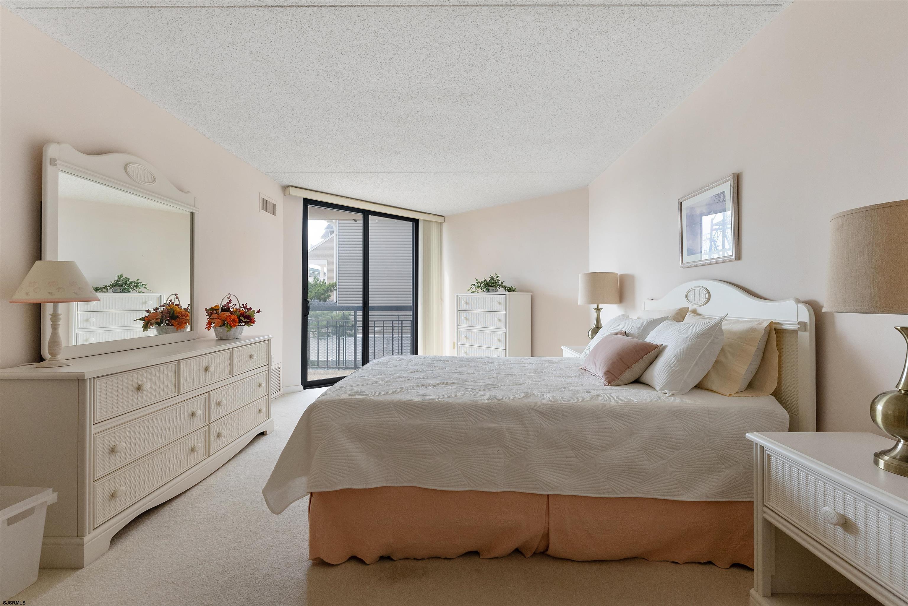 935 Ocean Avenue, Unit 319 Ocean City, NJ 08226 - Photo 10 of 24 a bedroom with a bed and a dresser