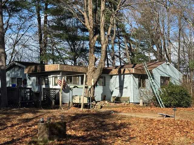 a front view of a house with a tree