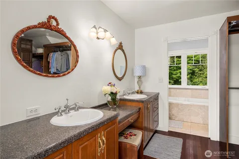 a bathroom with a granite countertop double vanity and a mirror