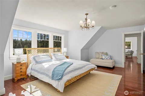 a bedroom with a large bed and a chandelier