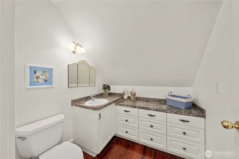 a bathroom with a granite countertop sink mirror vanity and toilet