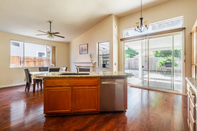 a kitchen with kitchen island granite countertop wooden cabinets a sink and a stainless steel appliances