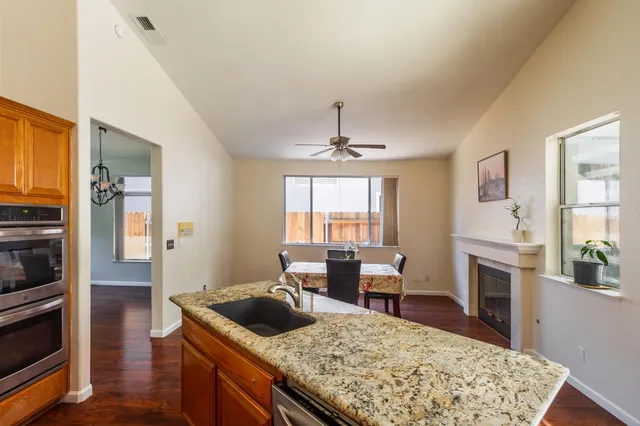 an empty room with windows and ceiling fan
