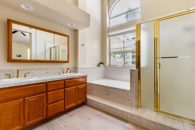 a spacious bathroom with a tub sink and mirror