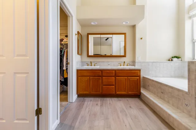 a bathroom with a tub sink and mirror
