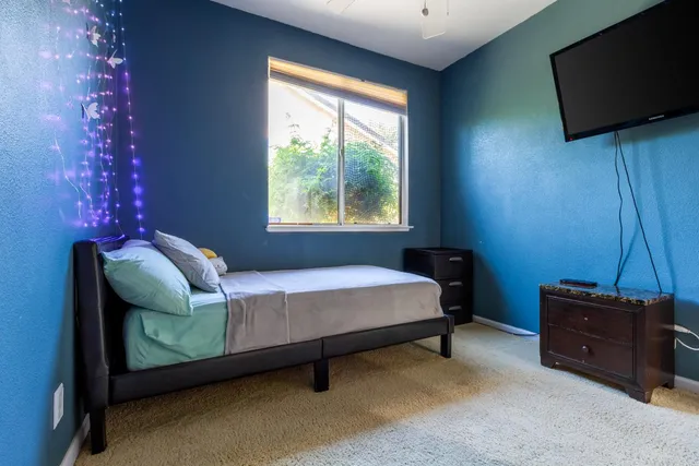 a bedroom with a bed and a flat screen tv