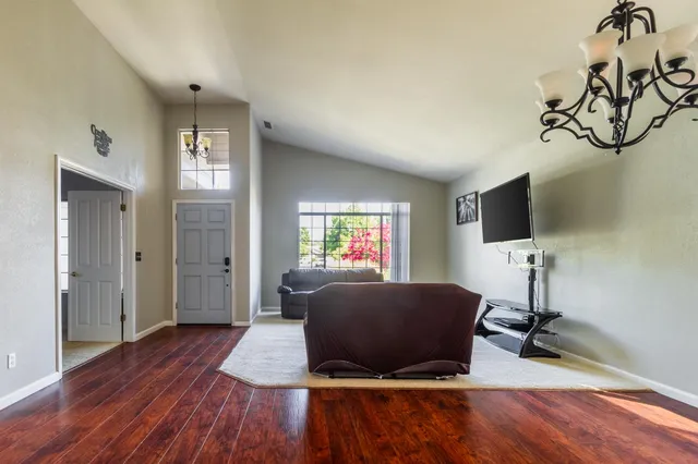 a living room with furniture flat screen tv and wooden floor