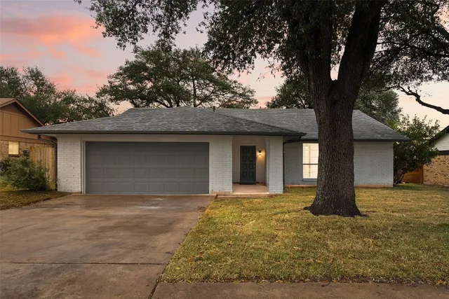 a front view of a house with yard and trees