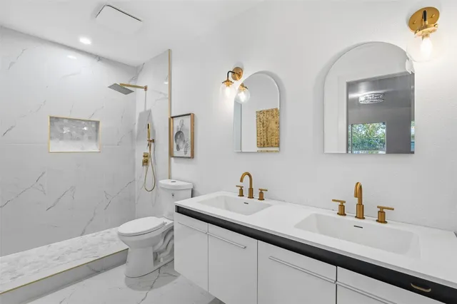 a bathroom with a toilet sink and mirror