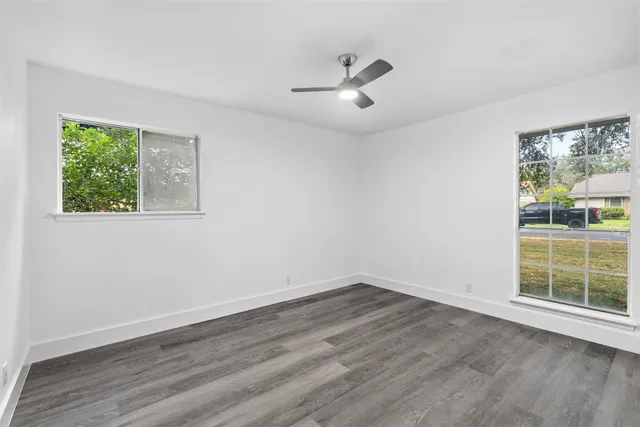 a view of a big room with wooden floor and windows in a room