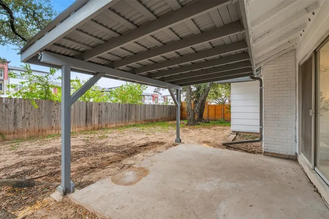a backyard with wooden fence and a porch