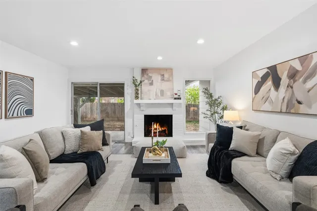a living room with furniture a fireplace and wall paintings