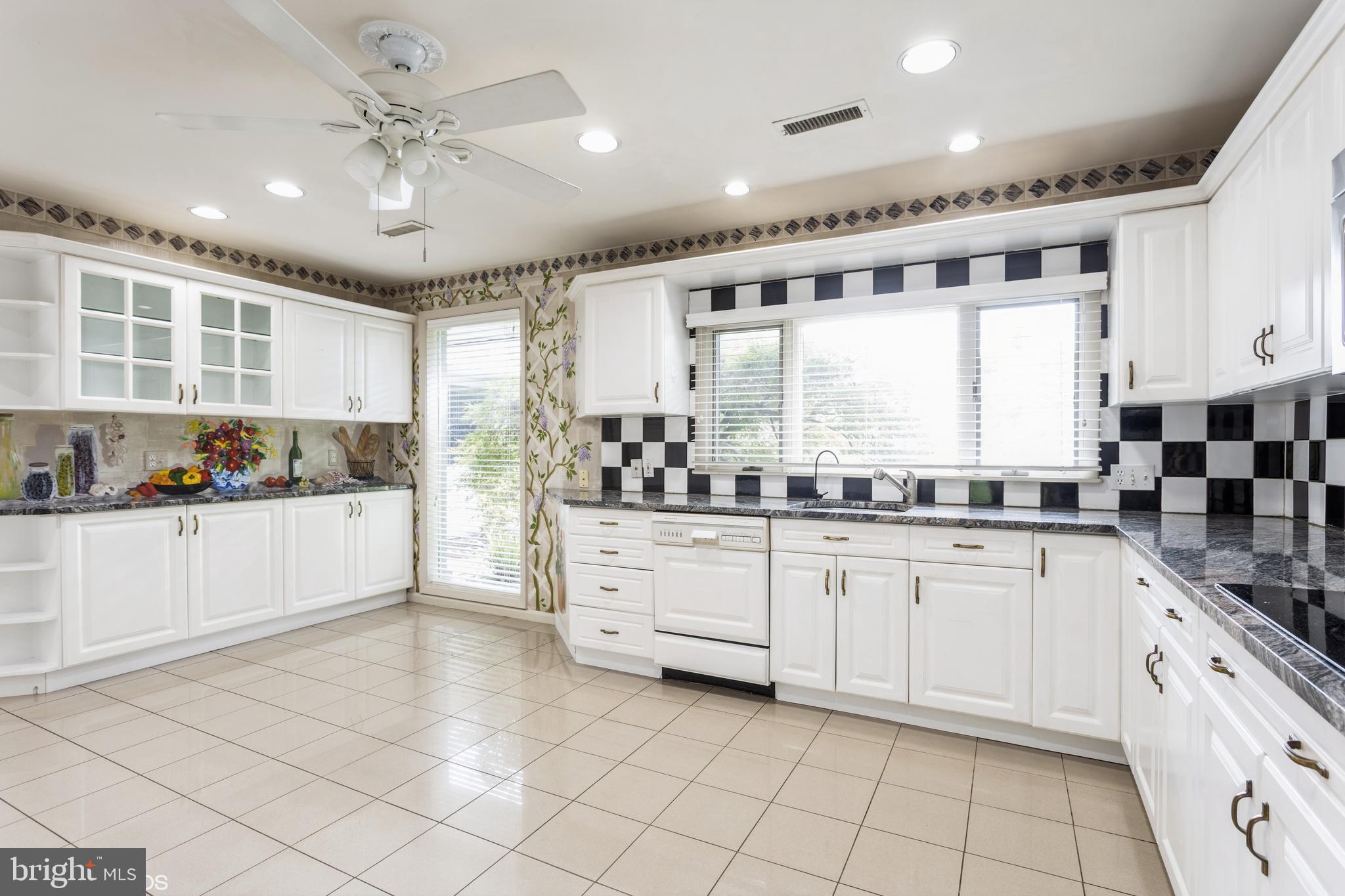 7920 Long Meadow Road Baltimore, MD 21208 - Photo 9 of 40 a large white kitchen with lots of counter space and window