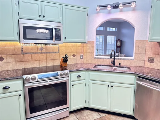 a kitchen with a stove microwave and sink