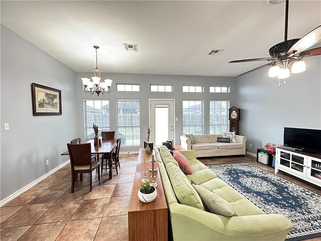 a living room with furniture a chandelier and a dining table