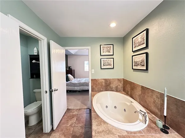 a en suite bathroom with a tub double vanity and view bedroom
