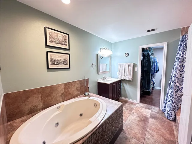 a bathroom with a tub a sink and a mirror