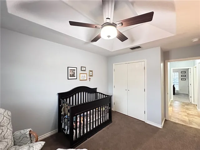 a bedroom with chandelier fan and wooden floor