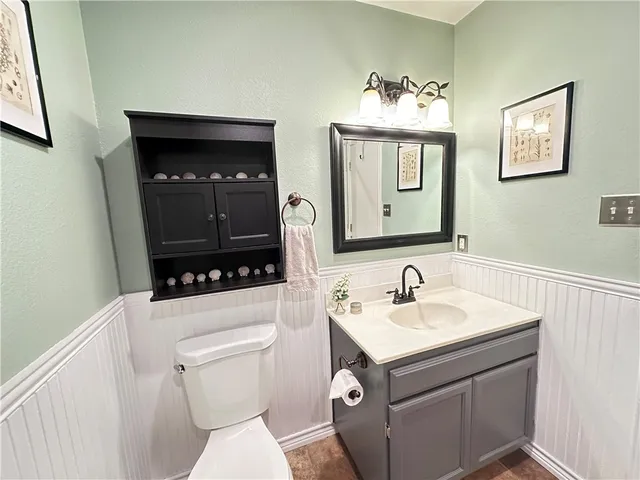 a bathroom with a toilet a sink and a mirror