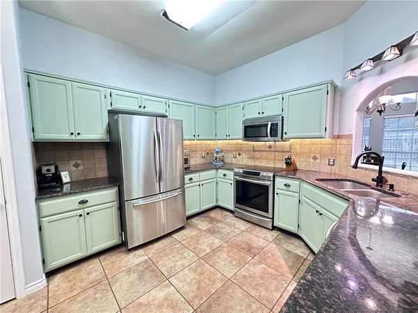 a kitchen with a sink cabinets and stainless steel appliances