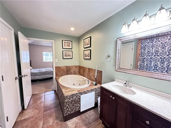 a bathroom with a double vanity sink a mirror and a bathtub
