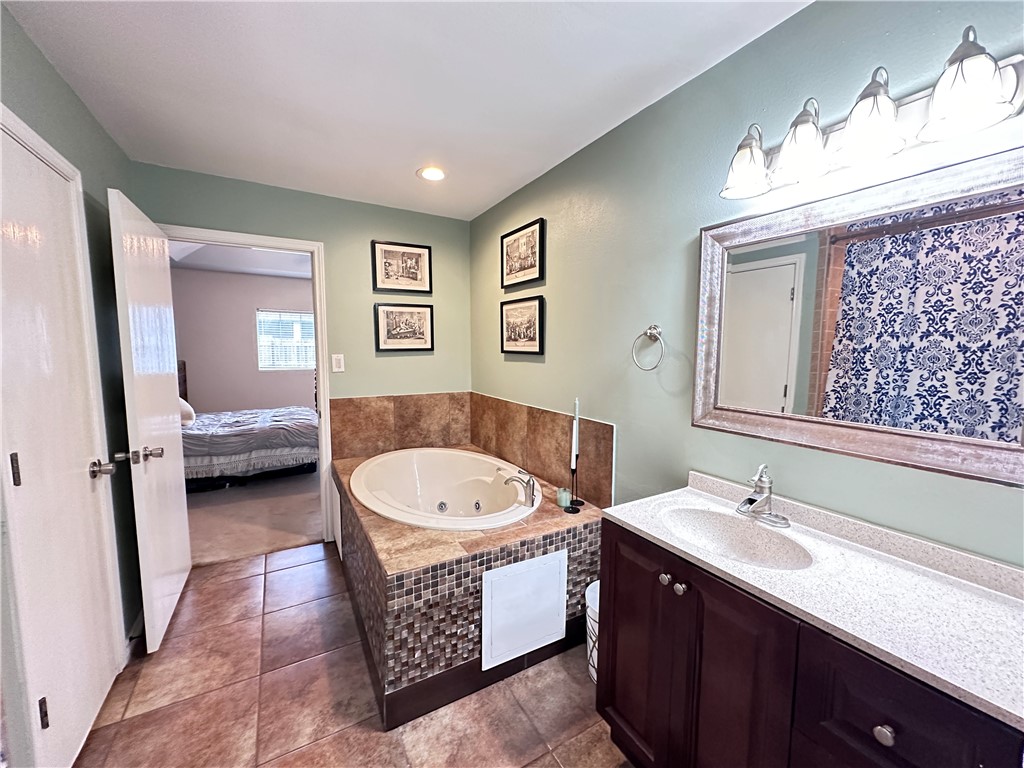 2106 Brook Lane Kingsville, TX 78363 - Photo 4 of 38 a bathroom with a double vanity sink a mirror and a bathtub