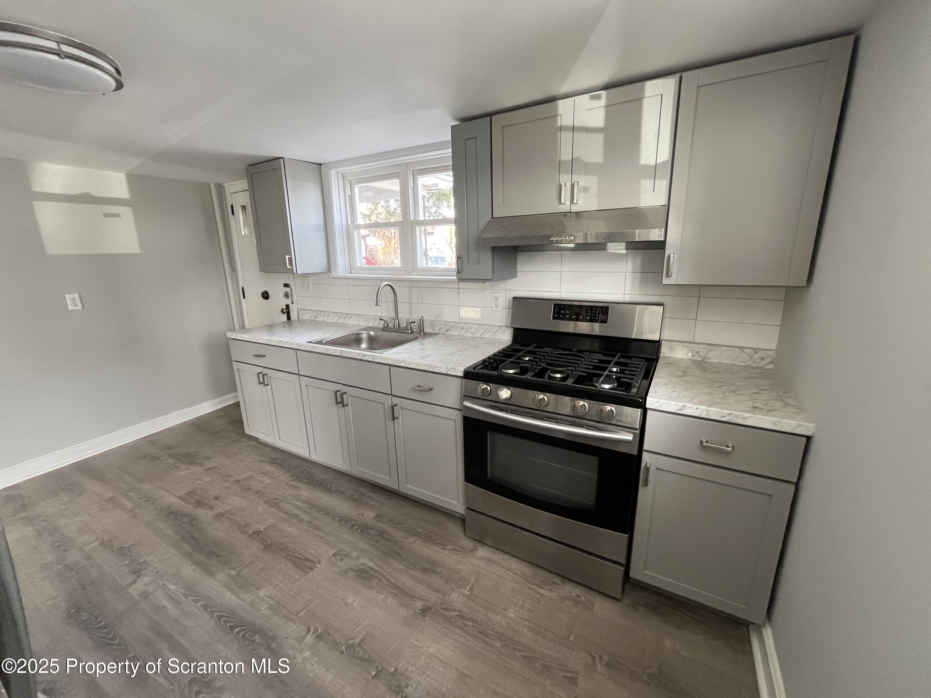 909 Battle Street Scranton, PA 18508 - Photo 5 of 13 a kitchen with stainless steel appliances granite countertop a sink stove and refrigerator