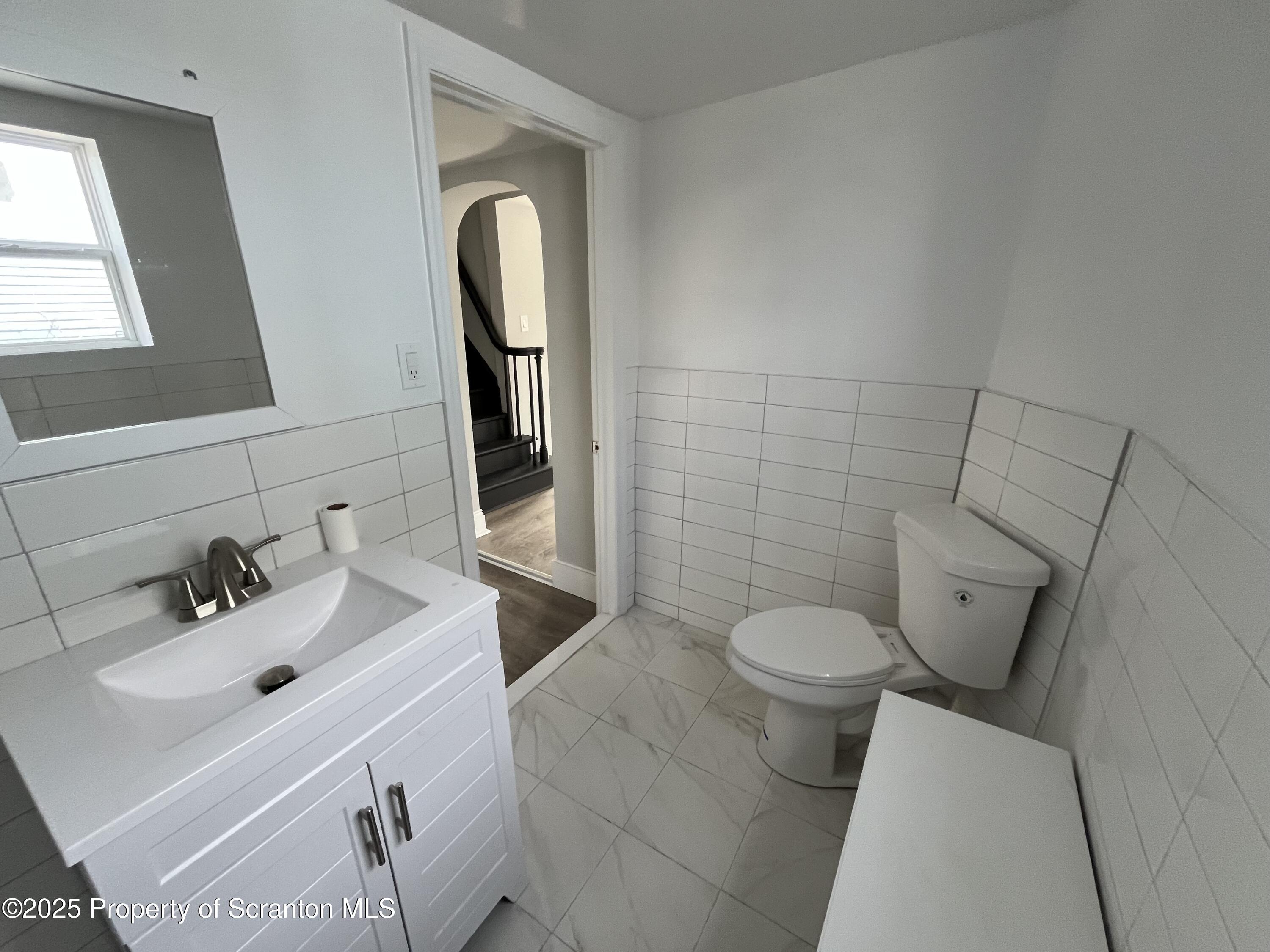 909 Battle Street Scranton, PA 18508 - Photo 8 of 13 a bathroom with a toilet sink and mirror