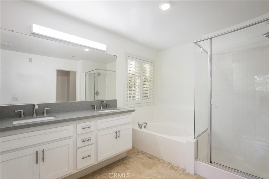 40 Platinum Circle Ladera Ranch, CA 92694 - Photo 11 of 15 a bathroom with a granite countertop sink a mirror a bathtub and shower