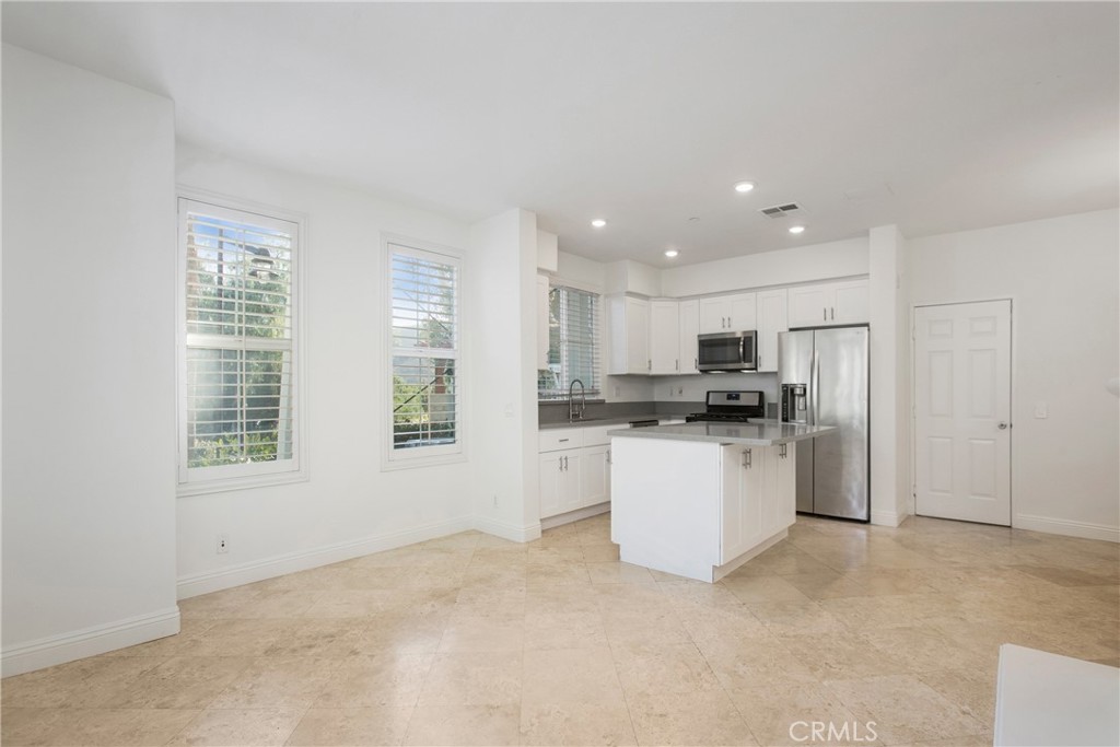 40 Platinum Circle Ladera Ranch, CA 92694 - Photo 5 of 15 a kitchen with a refrigerator and white cabinets