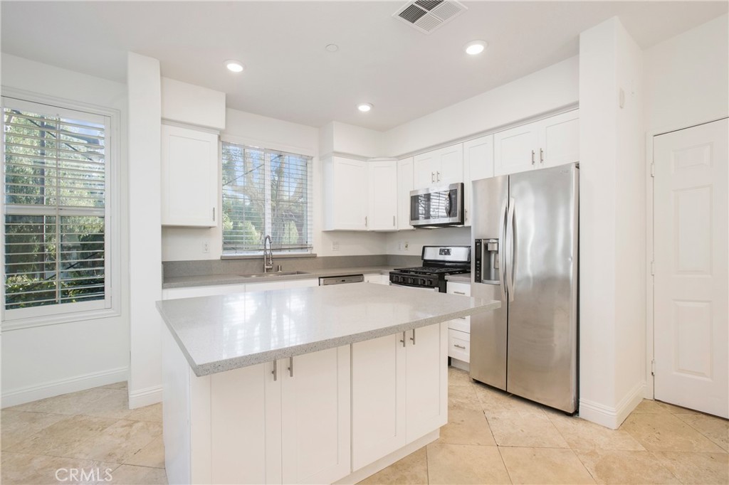 40 Platinum Circle Ladera Ranch, CA 92694 - Photo 7 of 15 a kitchen with stainless steel appliances granite countertop a refrigerator a sink a stove a microwave and island