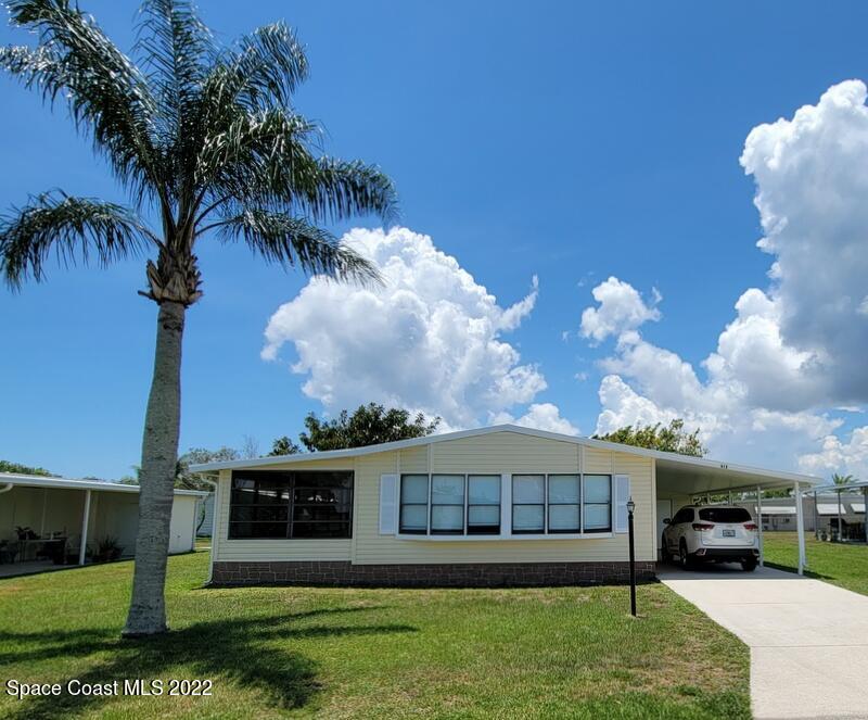 a view of a house with a yard and potted plants