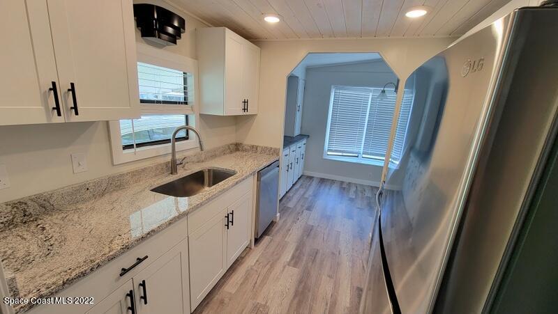 915 Fir Street Sebastian, FL 32976 - Photo 5 of 33 a kitchen with granite countertop a sink a stove and refrigerator