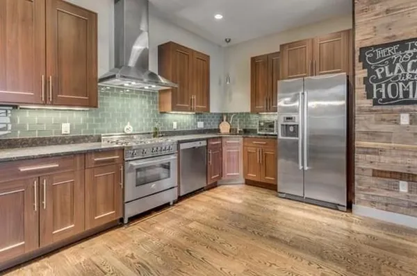 a kitchen with stainless steel appliances granite countertop a refrigerator sink and cabinets