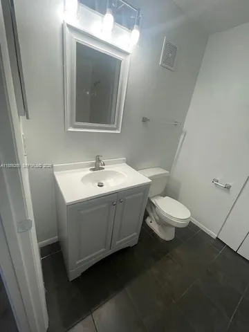 a bathroom with a sink mirror and toilet