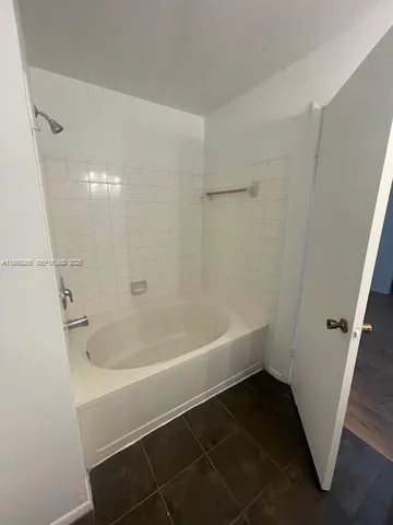 a white bath tub sitting next to a shower