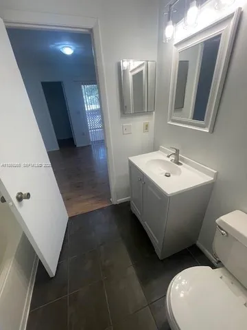 a bathroom with a sink a toilet and mirror