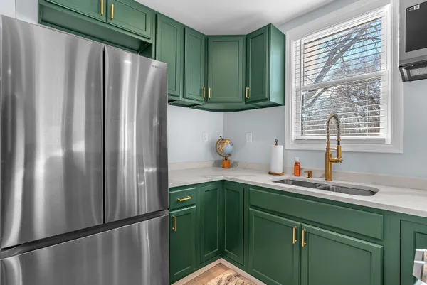 a kitchen with stainless steel appliances granite countertop a refrigerator and a sink