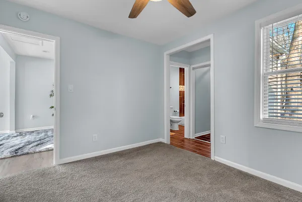 an empty room with ceiling fan and window