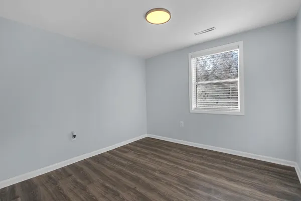 a view of a room with wooden floor and windows