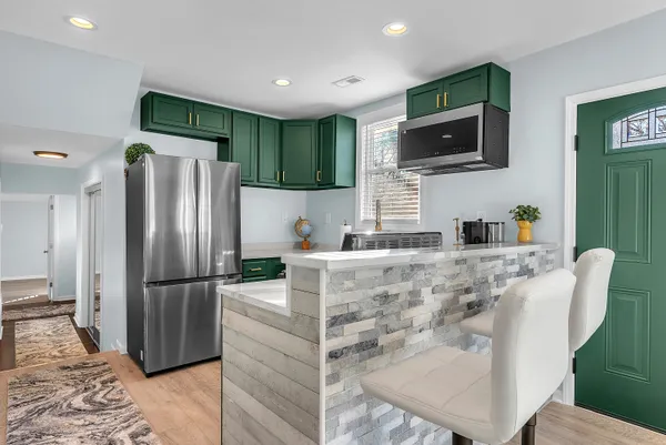 a kitchen with stainless steel appliances granite countertop a refrigerator a stove top oven a sink and dishwasher